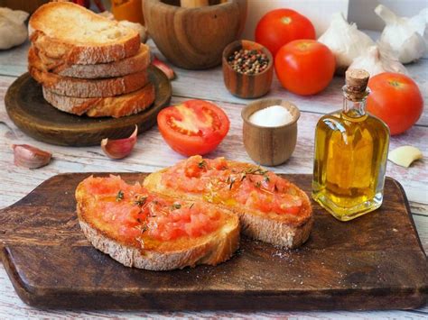 Infografía o ilustración histórica sobre el origen del pan con tomate y la llegada del tomate a Europa.