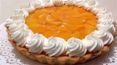 Tarta de durazno horneada, con crema y decorada con trozos de durazno