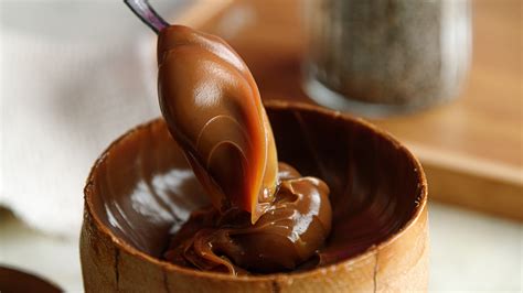 Foto de dulce de leche en un recipiente con una cuchara