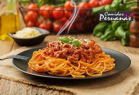 Plato de Tallarines Rojos con carne molida acompañado de Papa a la Huancaína, en un contexto de mesa familiar.