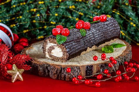Foto de un Tronco de Chocolate casero bellamente decorado con azúcar glas y frutos rojos