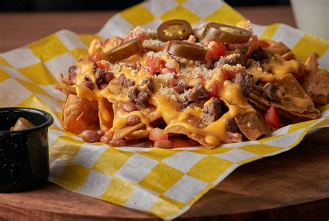 variedad de ingredientes para nachos: quesos, jalapeños, bacon, guacamole
