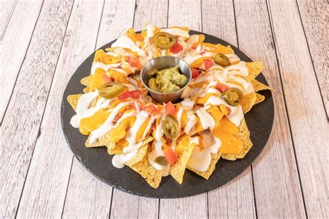 bandeja de nachos recién hechos con queso derretido, servidos con cerveza