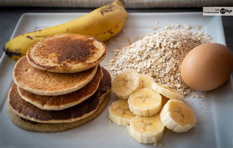 Fotografía de los ingredientes de las tortitas proteicas (plátano, huevos, avena, proteína en polvo) dispuestos para la preparación.