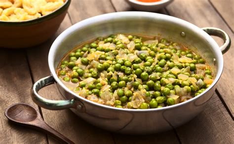 Plato humeante de guiso de arvejas frescas con mote de trigo, listo para servir