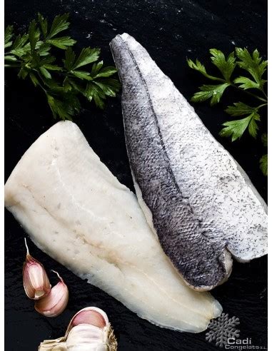 chef colocando un filete de merluza con la piel hacia abajo en una sartén muy caliente