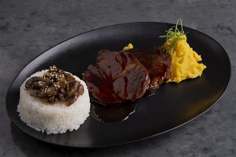 Foto principal de bondiola braseada con salsa de soja y miel, decorada con hierbas