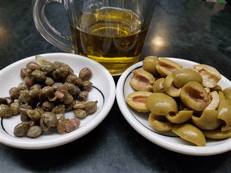 Ingredientes frescos para salsa con aceitunas y alcaparras