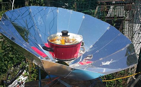 Cocina solar parabólica en funcionamiento, concentrando la luz solar