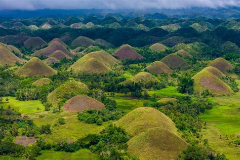 Fotografía aérea de las Colinas de Chocolate con un valle cultivado en primer plano, resaltando la convivencia de la naturaleza y la agricultura.