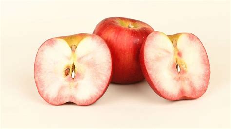 Primer plano de una manzana de pulpa roja cortada transversalmente, mostrando la intensa coloración interna.