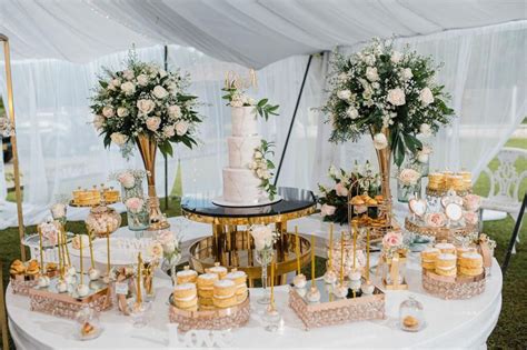 Fotografía profesional de una mesa de pastel elegantemente decorada en una recepción de bodas