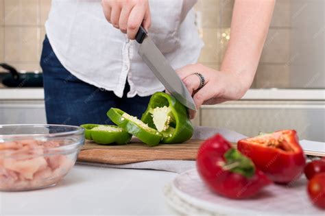 Primer plano de un cuchillo afilado cortando finas láminas de salmón congelado.