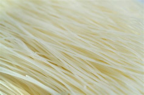 Foto de fideos de arroz crudos y sus ingredientes principales (harina de arroz, agua)