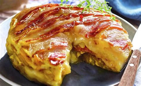 Tortilla española con jamón y queso fundido, mostrando el interior cremoso.