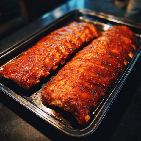 costillas marinándose en una bandeja con papel film