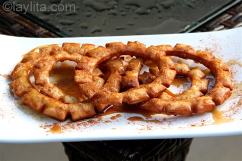 Postres ecuatorianos bañados en miel de panela, incluyendo pristiños y buñuelos
