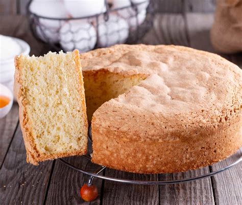 Capa de bizcocho siendo cubierta con crema de mantequilla durante el ensamblaje