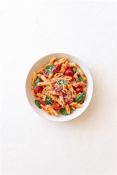 Plato de pasta con tomates deshidratados, albahaca y queso parmesano