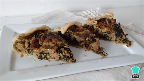 Imagen de un pastel de acelga con carne molida recién horneado, cortado en porciones.