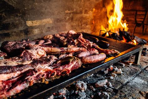 Fotografía de gauchos preparando un asado a la leña.