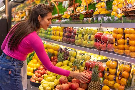 Persona comprando frutas y verduras en un mercado, simbolizando la planificación de la dieta vegana