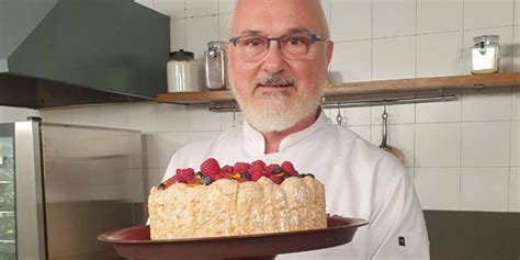 Retrato de Osvaldo Gross, chef pastelero, junto a una tarta de nuez.
