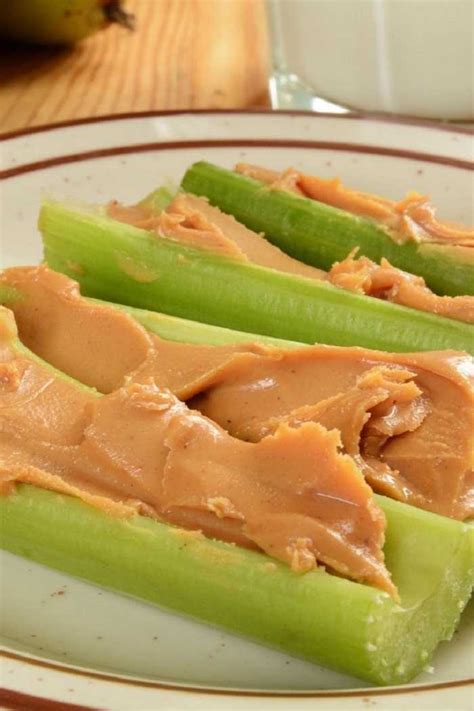 Palitos de apio decorados con crema de cacahuete, pasas y trozos de manzana
