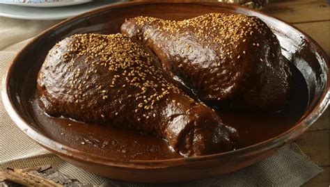 Salsa de chocolate espesa en una cazuela con trozos de pollo