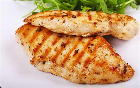 Fotografía de una pechuga de pollo a la plancha con espárragos y limón.