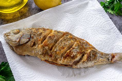 Pescado frito dorado y crujiente servido con una ensalada colorida y papas cremosas.