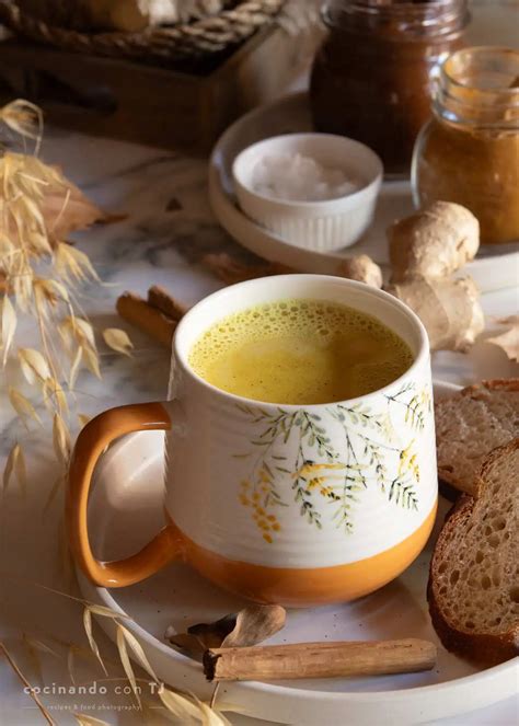 Tazón de leche dorada humeante con especias espolvoreadas