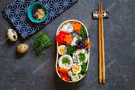 Bento box japonesa con onigiris y otros alimentos