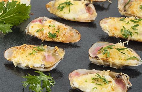 Machas a la parmesana gratinadas y servidas en una bandeja