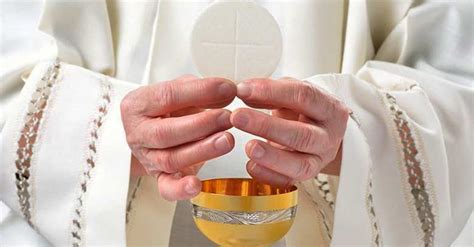 Detalle de las manos del sacerdote sosteniendo la hostia y el cáliz durante la consagración