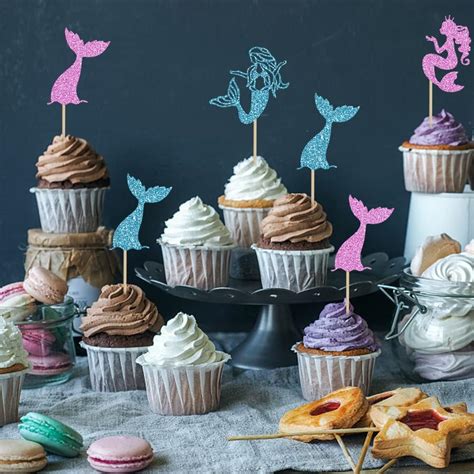 Cupcakes temáticos de sirena con glaseado colorido y adornos de cola de sirena