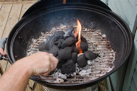Montón de carbón vegetal de calidad preparado en una parrilla, encendido y con capa gris de ceniza
