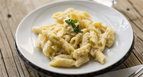 Fotografía de un plato de pasta cremosa a los cuatro quesos con un toque de perejil fresco