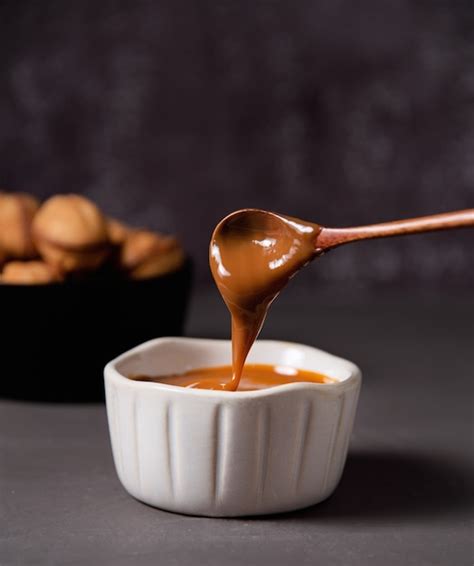 Foto de una cuchara sirviendo salsa de caramelo sobre un postre