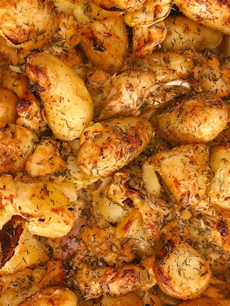 fotografía de patatas cortadas y sazonadas en fuente de horno