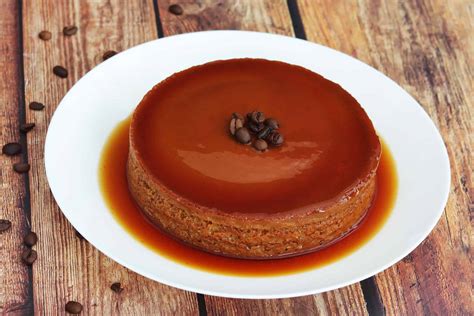 Foto de un flan de café recién desmoldado con caramelo brillante y un toque de nata o granos de café.