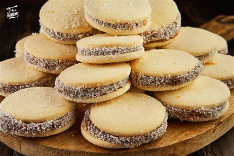 Imagen de una selección de alfajores artesanales variados, algunos con coco y otros espolvoreados con azúcar flor