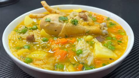 Fotografía de un plato de aguado de pollo servido en un cuenco tradicional, mostrando la textura espesa de la sopa con arroz y trozos de vegetales.