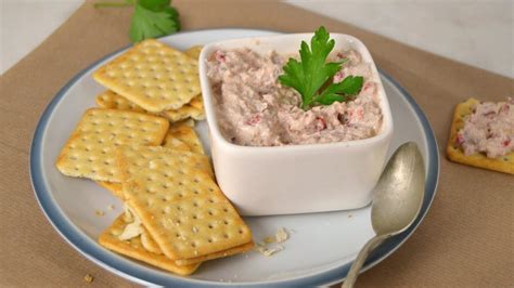 Plato elegante con mousse de atún servido sobre galletas saladas como aperitivo