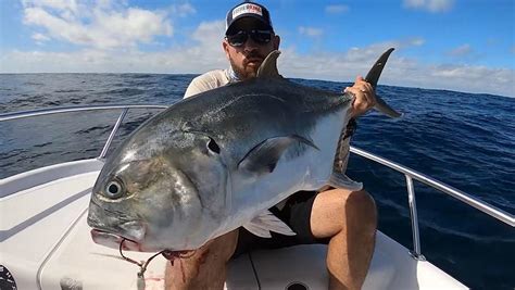 Pescador liberando un jurel capturado de vuelta al mar
