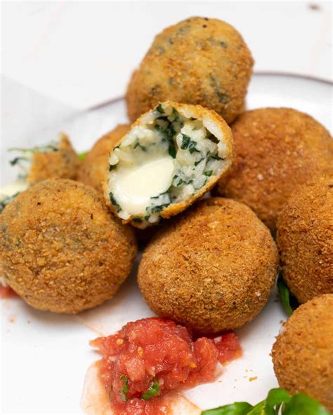 Foto de croquetas de arroz y espinaca doradas y crujientes, servidas en un plato.