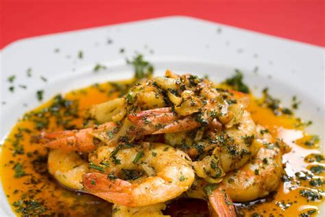 Plato de camarones al pilpil decorado con perejil y limón