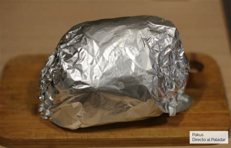 Infografía mostrando el proceso de reposo de la carne, con un bistec cubierto de papel aluminio sobre una tabla de cortar.