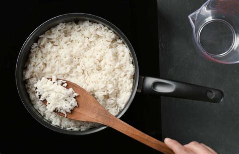 Olla tradicional con arroz cocinándose sobre una llama de fuego