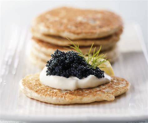 Plato de degustación de caviar con blinis, crema agria y cebollino